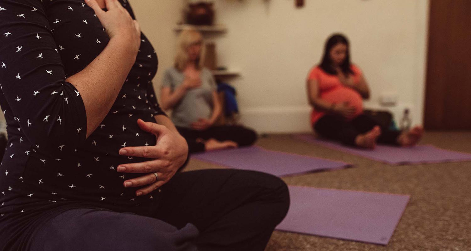 Women at an active birth yoga class on their mats